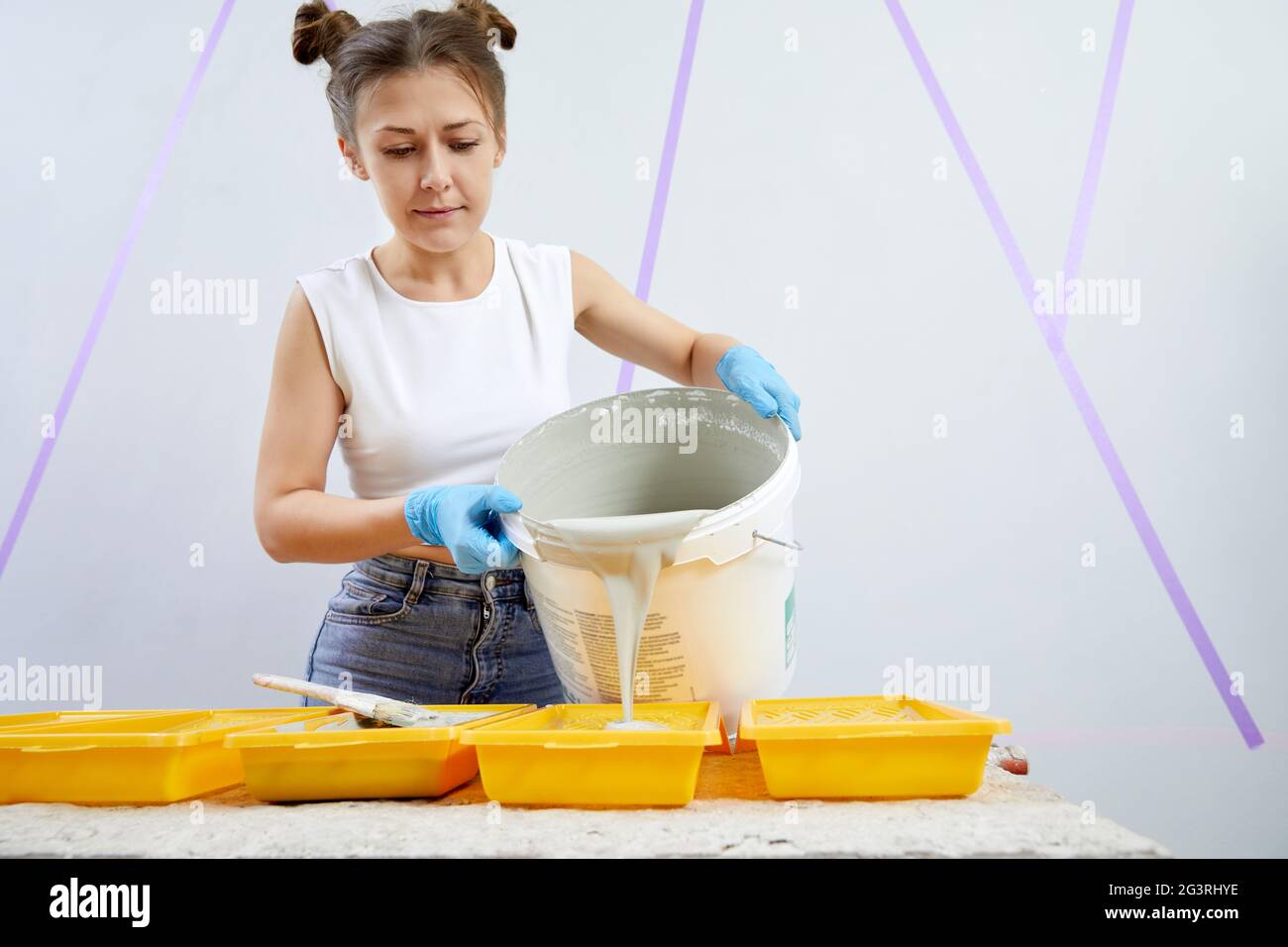 Young woman pouring paint into plastic paint tray Stock Photo Alamy