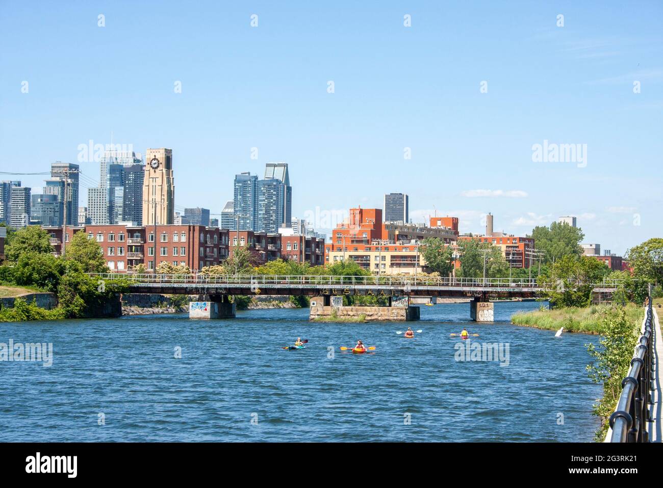 View of Downtown Montreal and the Atwater Market from the Lachine Canal with boats and kayaks floating along Stock Photo