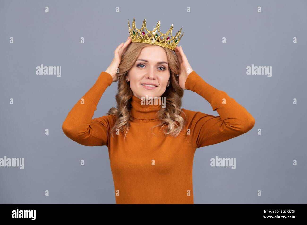 smiling blonde girl with curly hair wear crown, egoism Stock Photo
