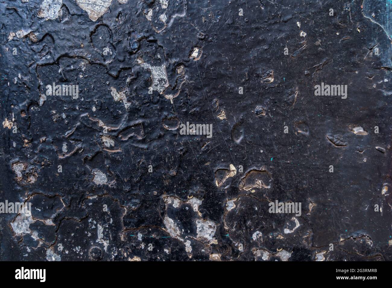 Grunge corroded metal surface with black paint peeling off and rust patterns Stock Photo