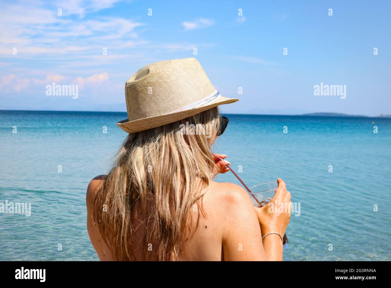 Woman with a hat in front of the sea Stock Photo