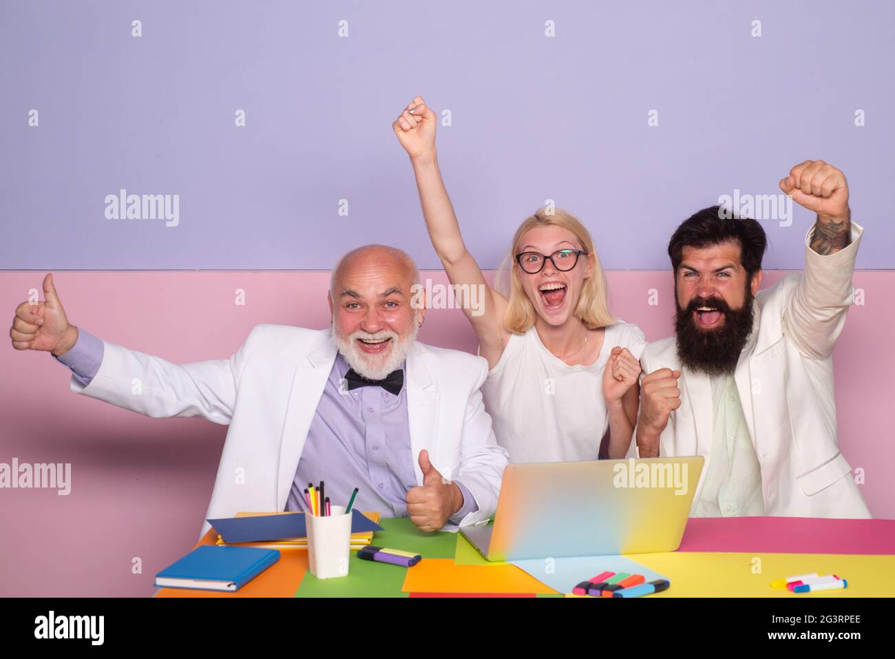 Excited businesspeople. Business winners. Group of happy business people looking at the laptop and gesturing. Business team celebrating a triumph with Stock Photo