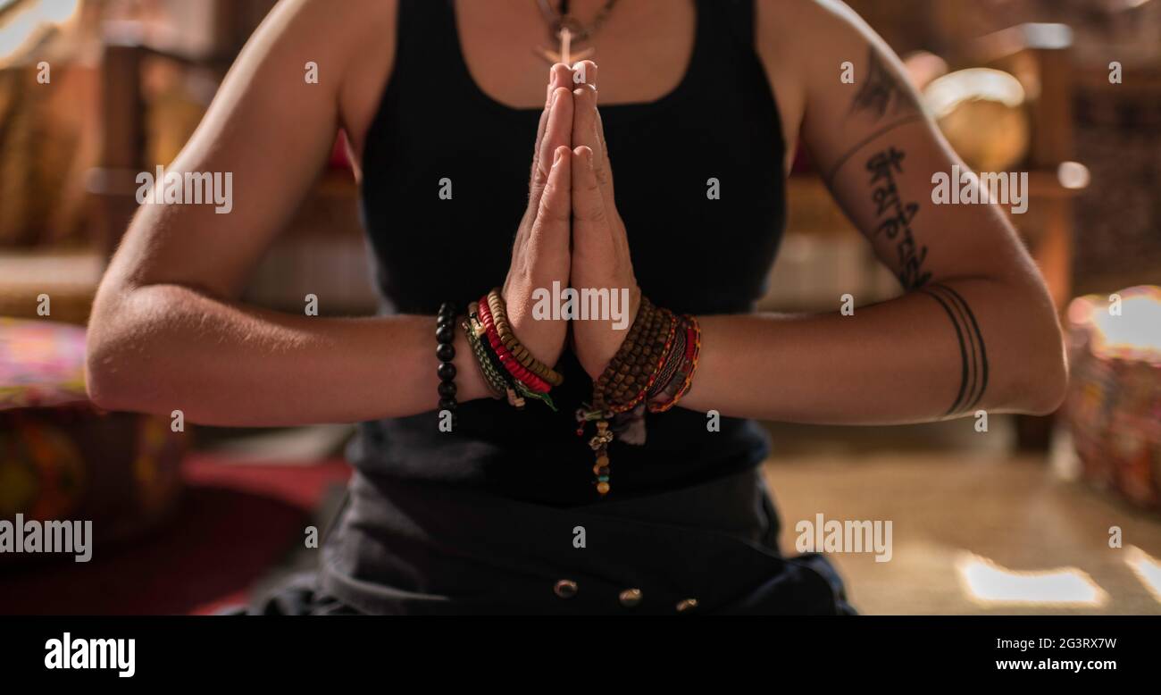 Cropped woman meditating with clasped hands Stock Photo