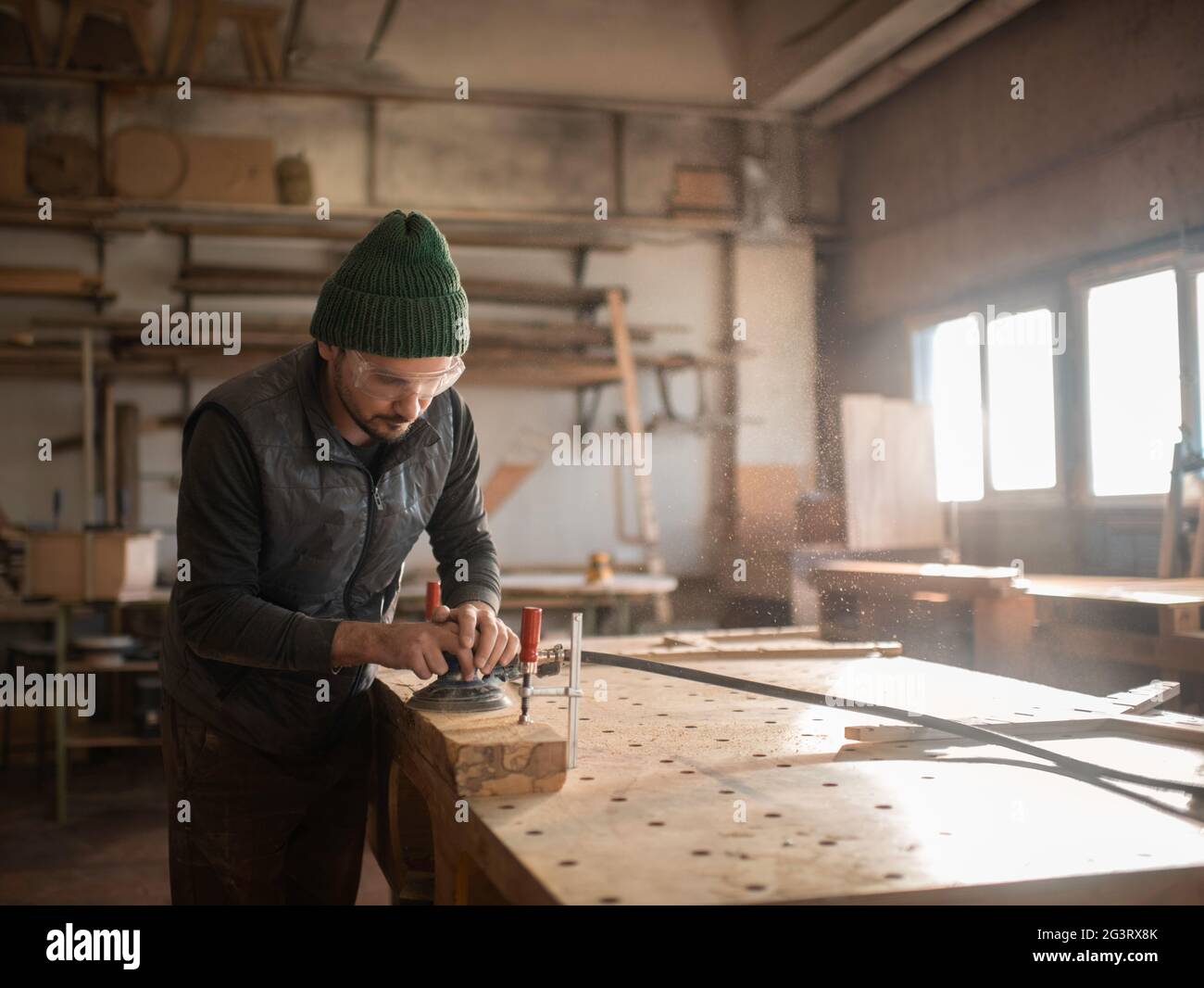 Male carpenter polishing wooden plank Stock Photo