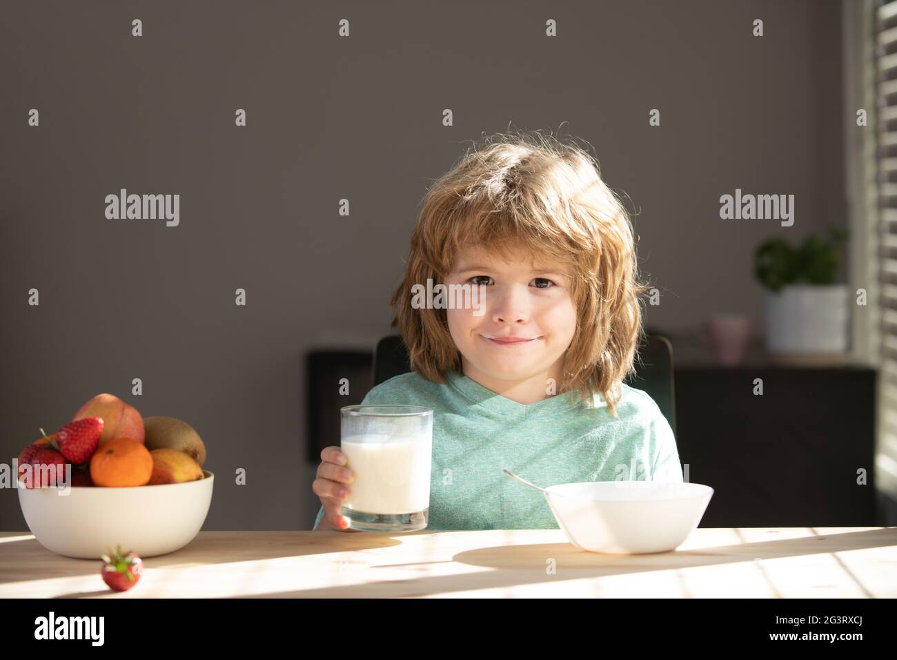 Young little boy with glass of milk. Kid eating breakfast. Child eating healthy food. Stock Photo