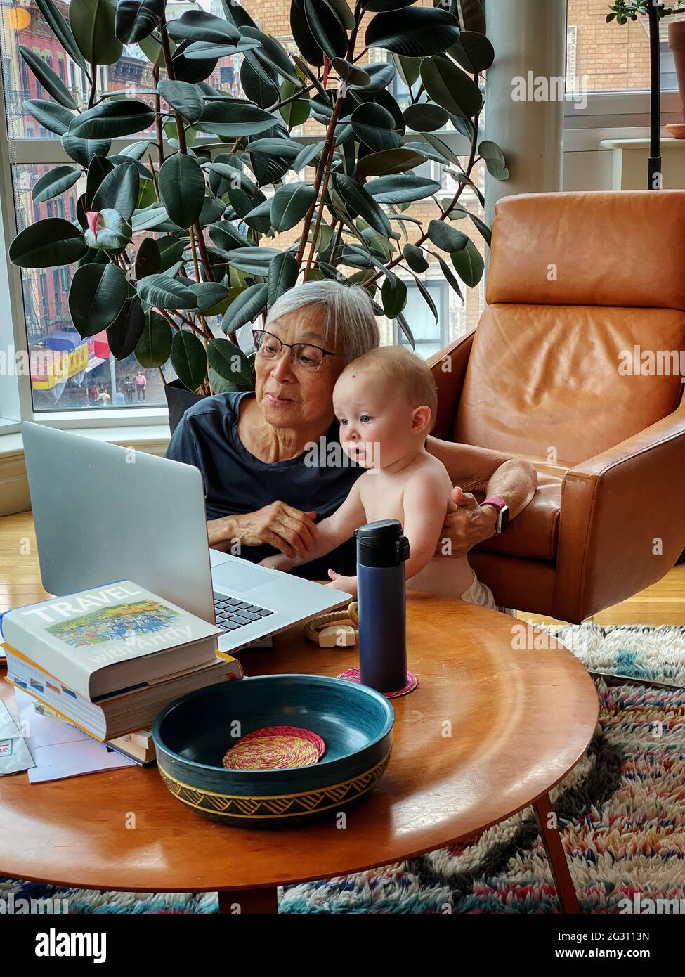 Asian Grandmother and Granddaughter using laptop together at home Stock Photo