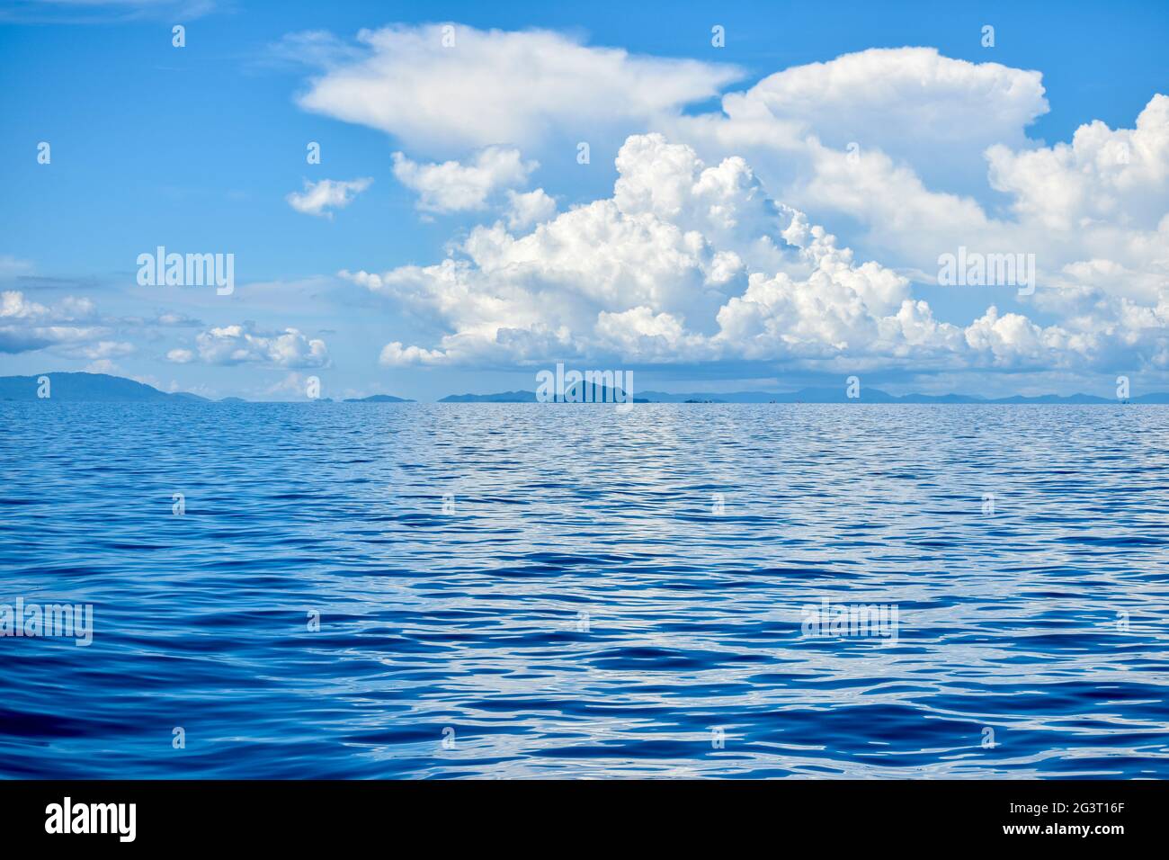 Blue ocean waves under bright sky with white clouds Stock Photo - Alamy