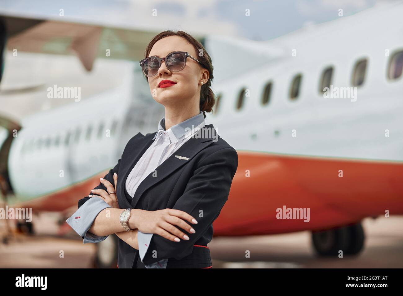 Thoughtful stewardess on runway near airplane jet Stock Photo