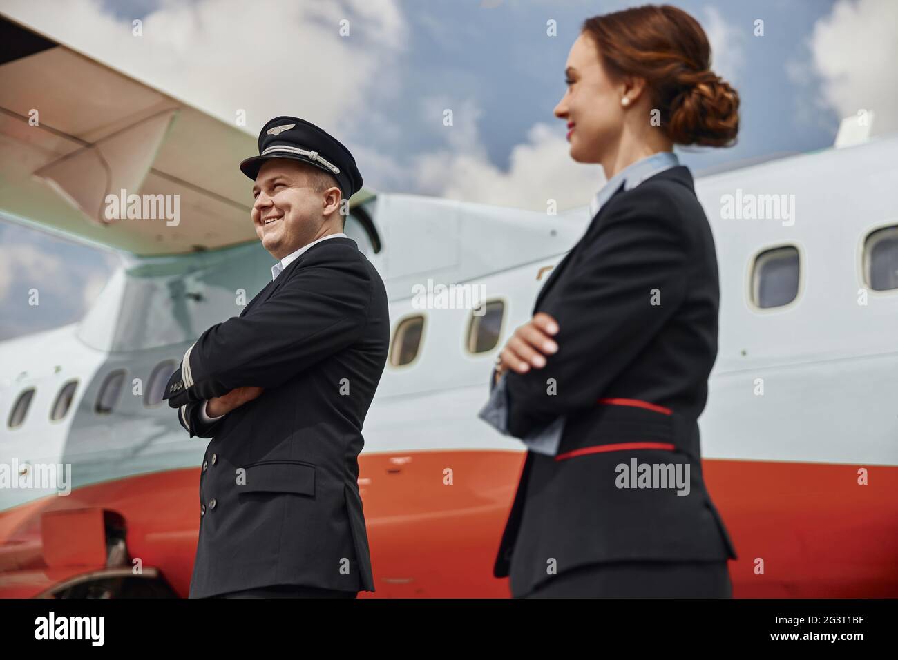 Pilot and stewardess on runway near airplane jet Stock Photo