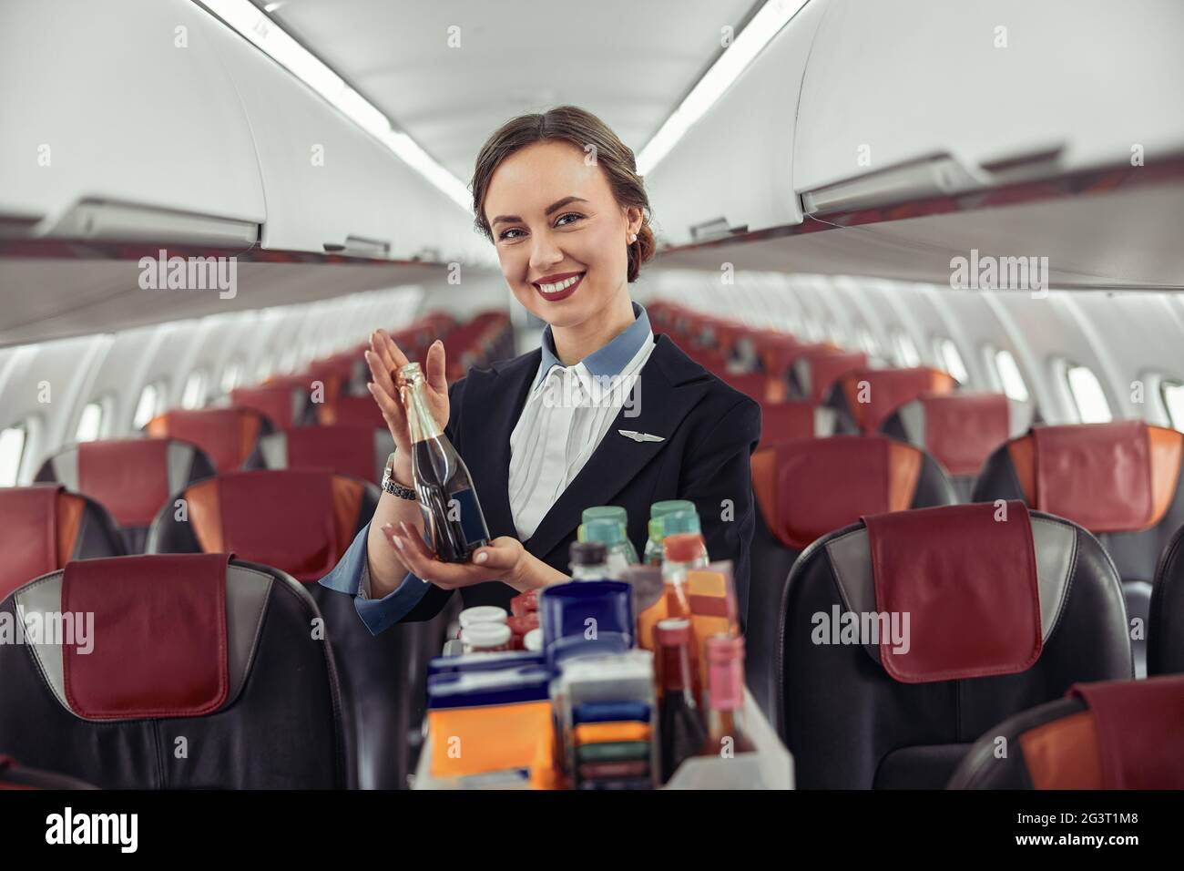 Stewardess show bottle with alcohol in airplane Stock Photo Alamy