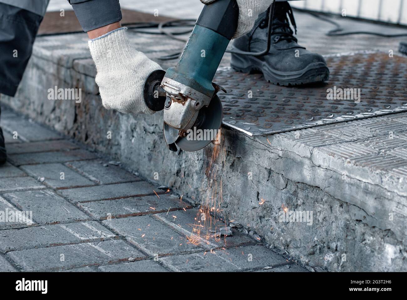 Processing of metal sheet with an angle-grinding tool Stock Photo