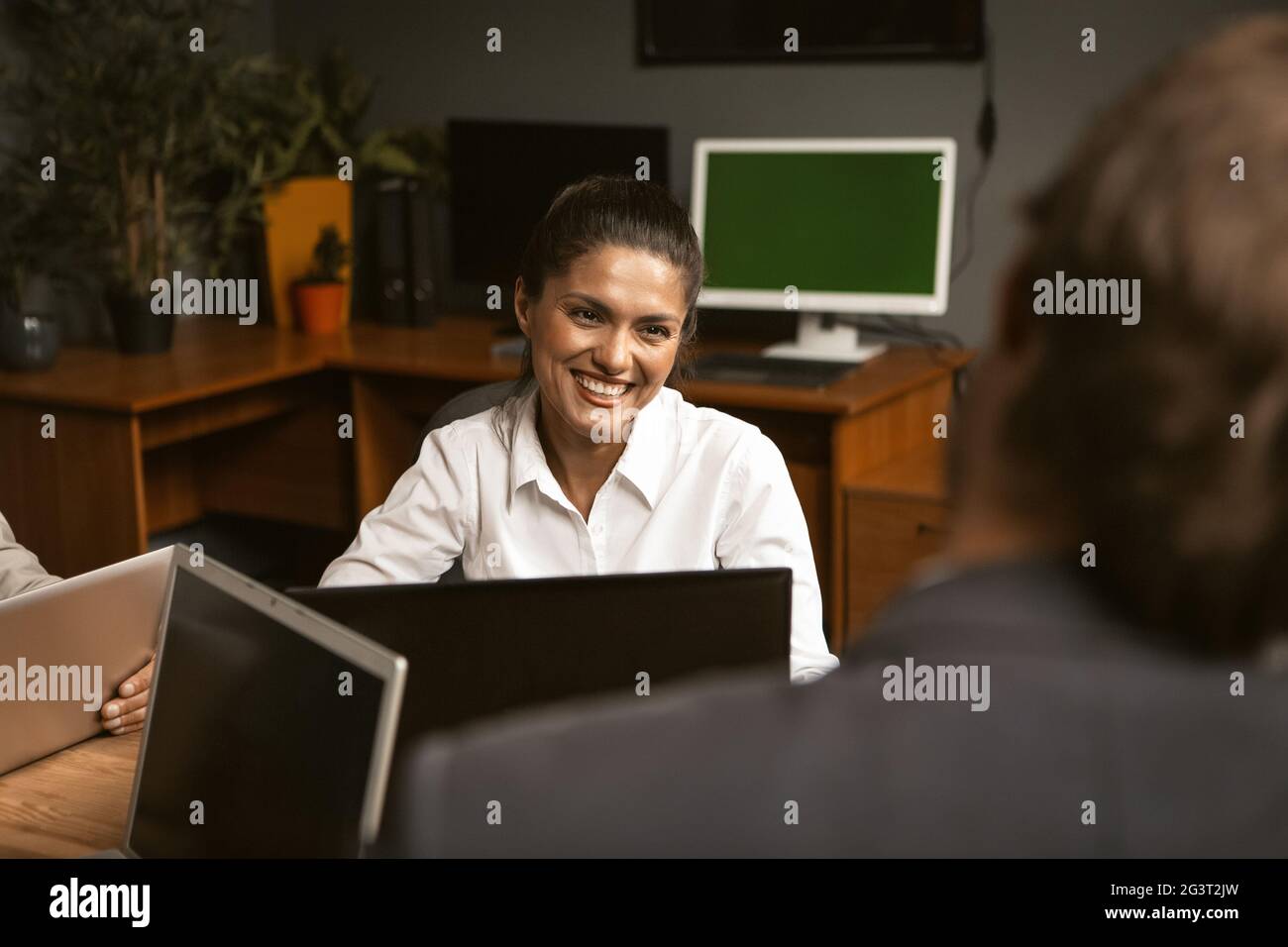 Smiling office worker, young woman in white shirt at interview. Stock Photo