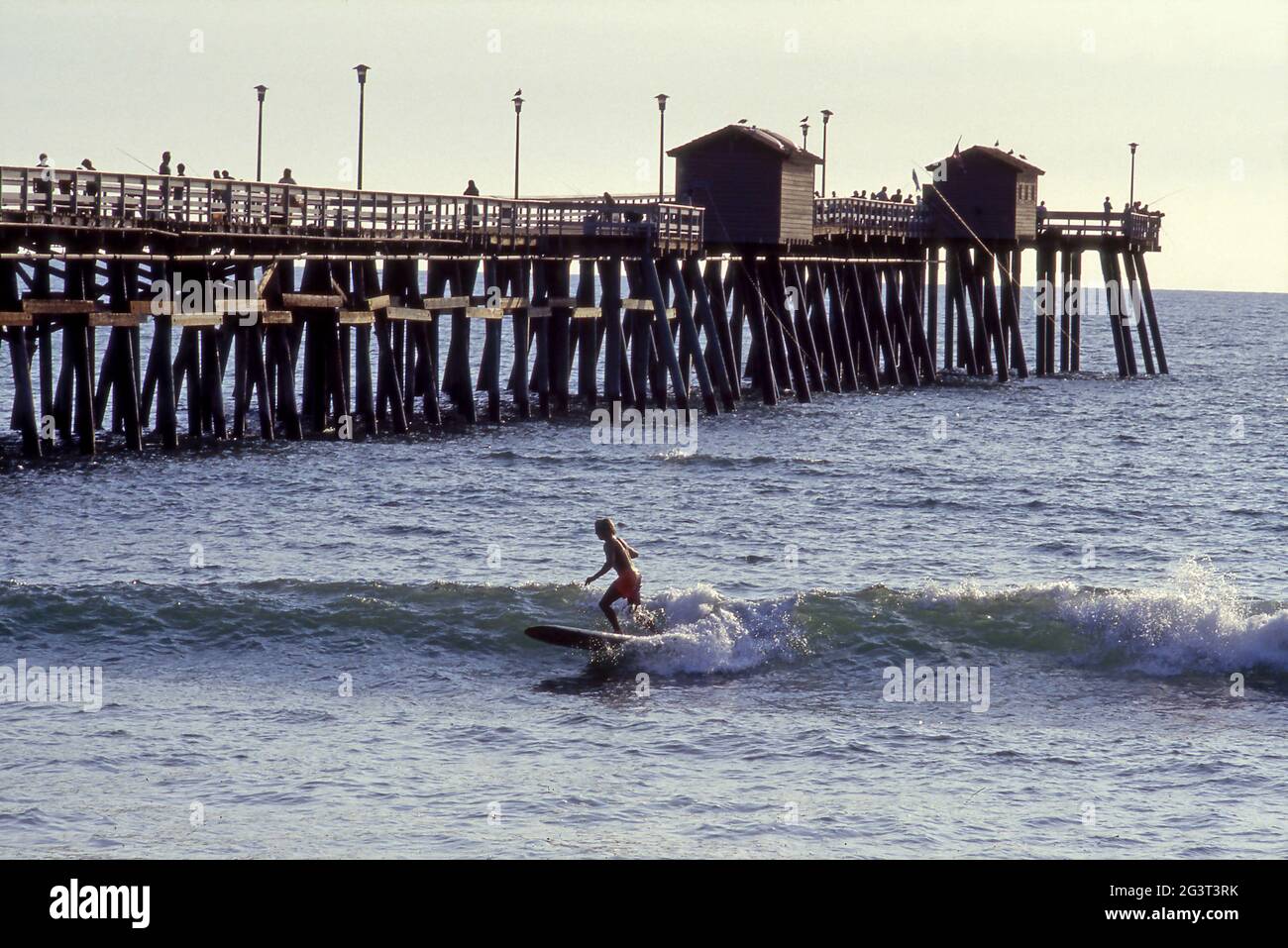 Surfer riding a wave near the San Clemente Pier on coast of Southern California. Stock Photo