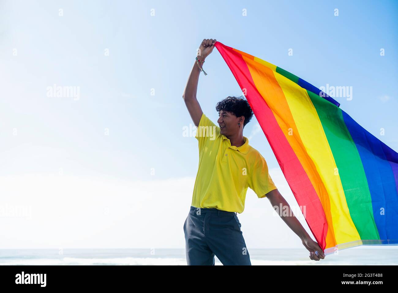 Young gay man proudly holding the lgbt flag in his hands in front of ...