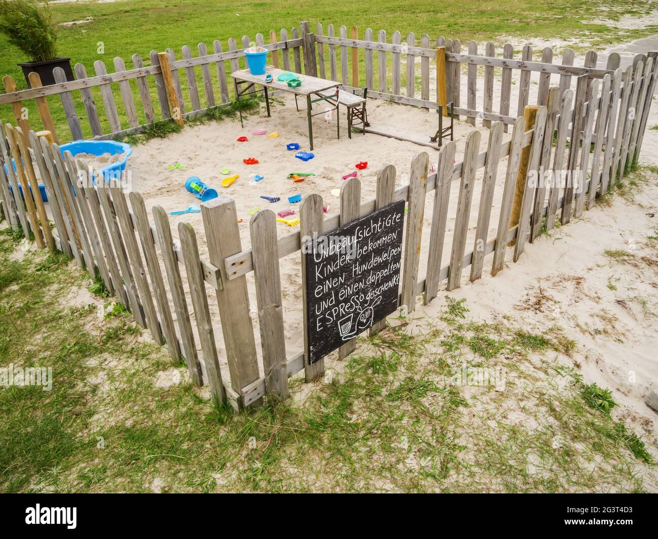 Fenced sandpit with toys Stock Photo