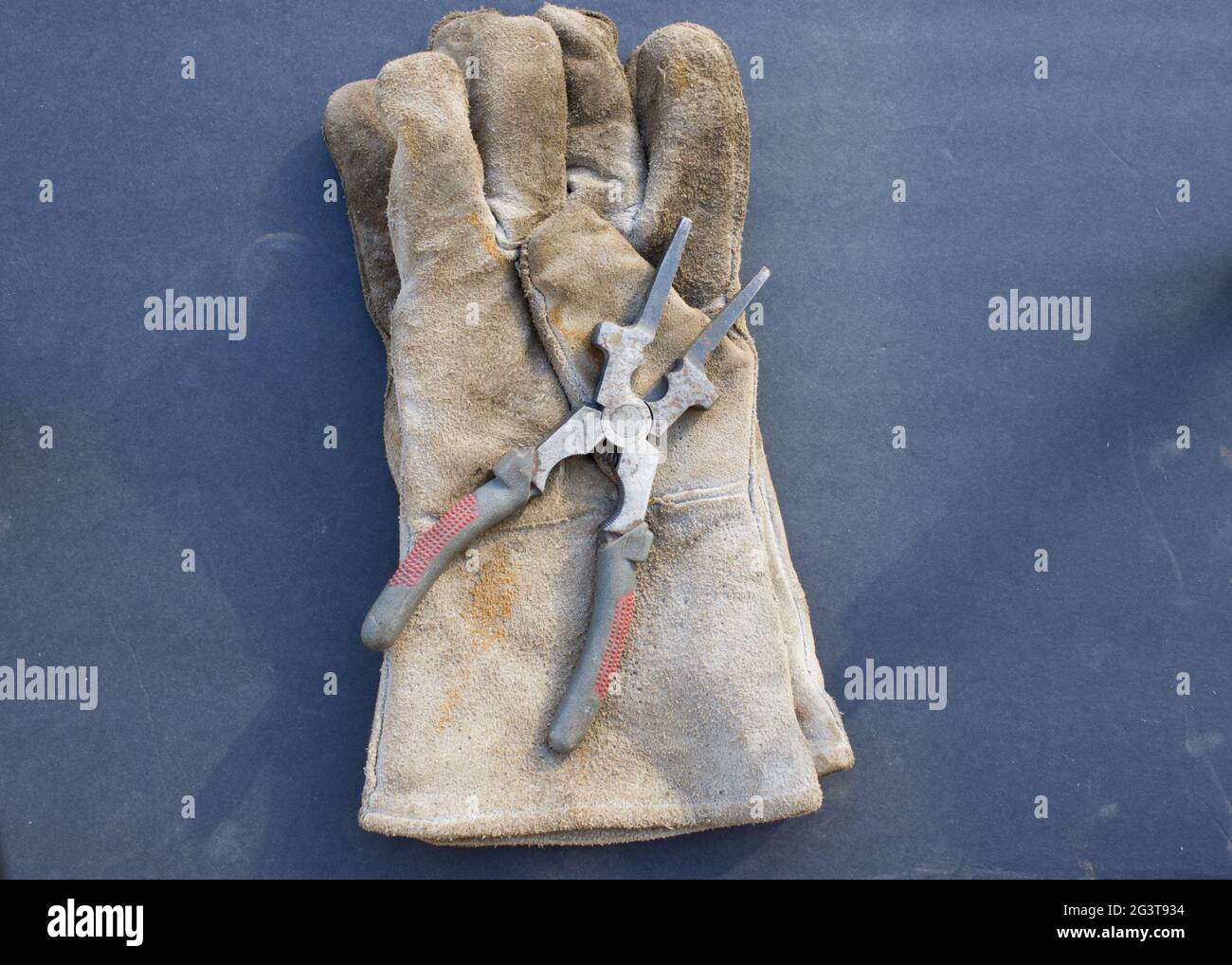 A Close Up of Welding Gloves and MIG Pliers Stock Photo
