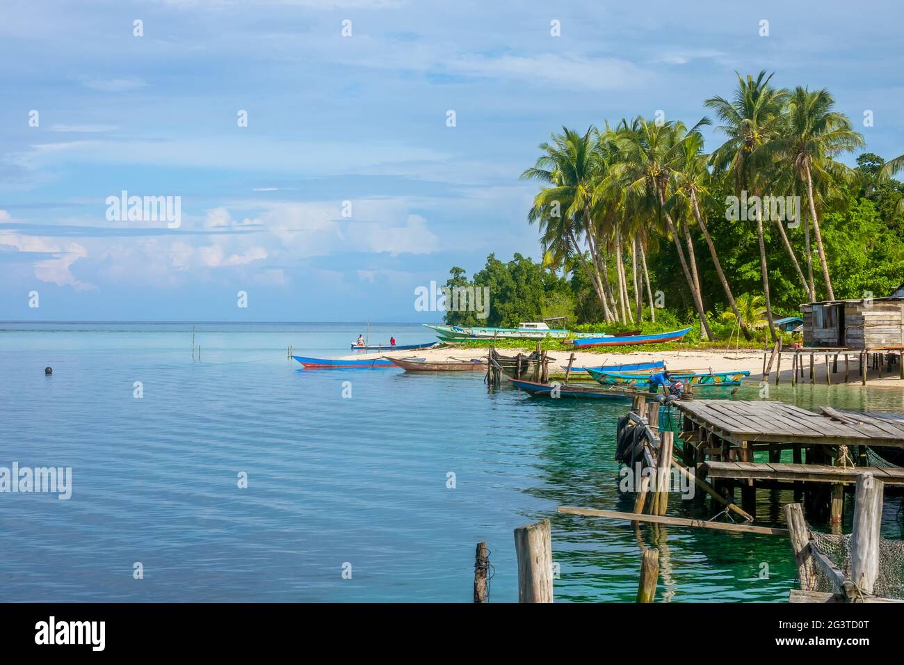 Old Pier and Boats at the Edge of a Tropical Village Stock Photo