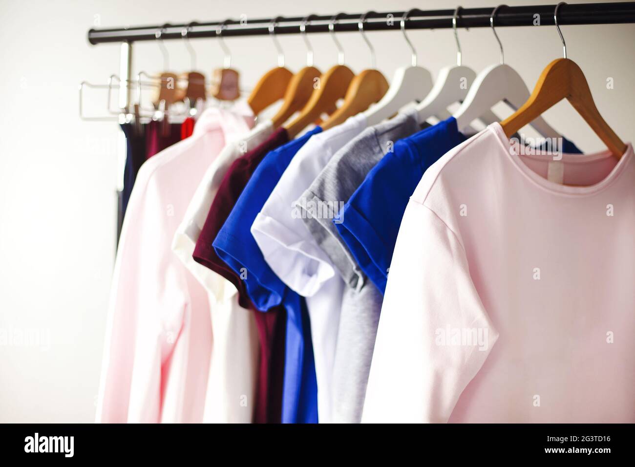 Colorful clothes hanging on rack in room Stock Photo Alamy