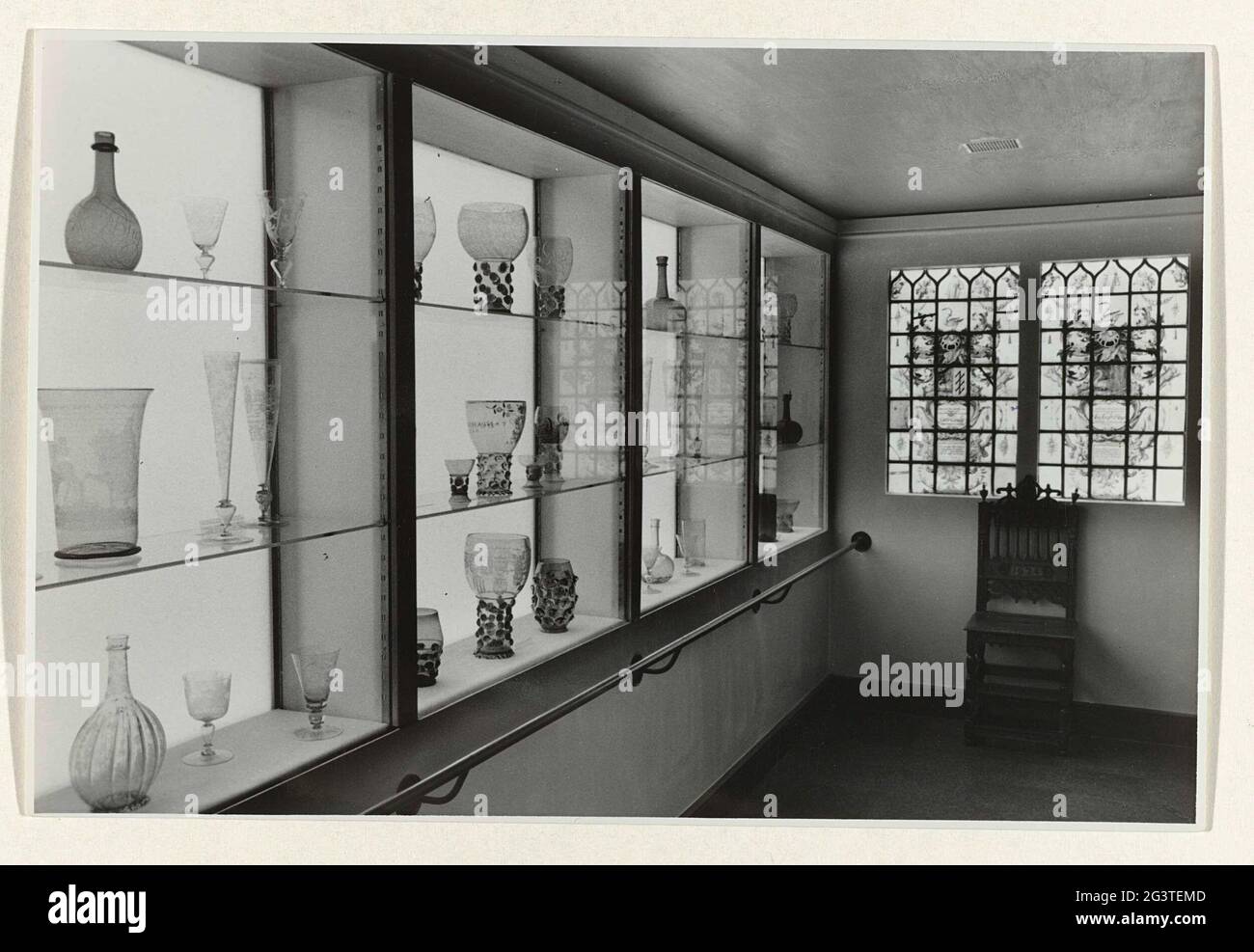 Room with arrangement of 17th century glassware in 1952. Room M253 (?) With 17th century glassware prepared in illuminated wall vitrins. On the back wall view of a double stained glass window. Modernization and redesign of approx. 60 rooms, Professional. FA. Eschaauzier and Bart castle. It concerned the halls sculpture / arts and crafts (XVIII), study collection, exhibition Rijkspentencabinet and public restaurant with kitchen. Stock Photo