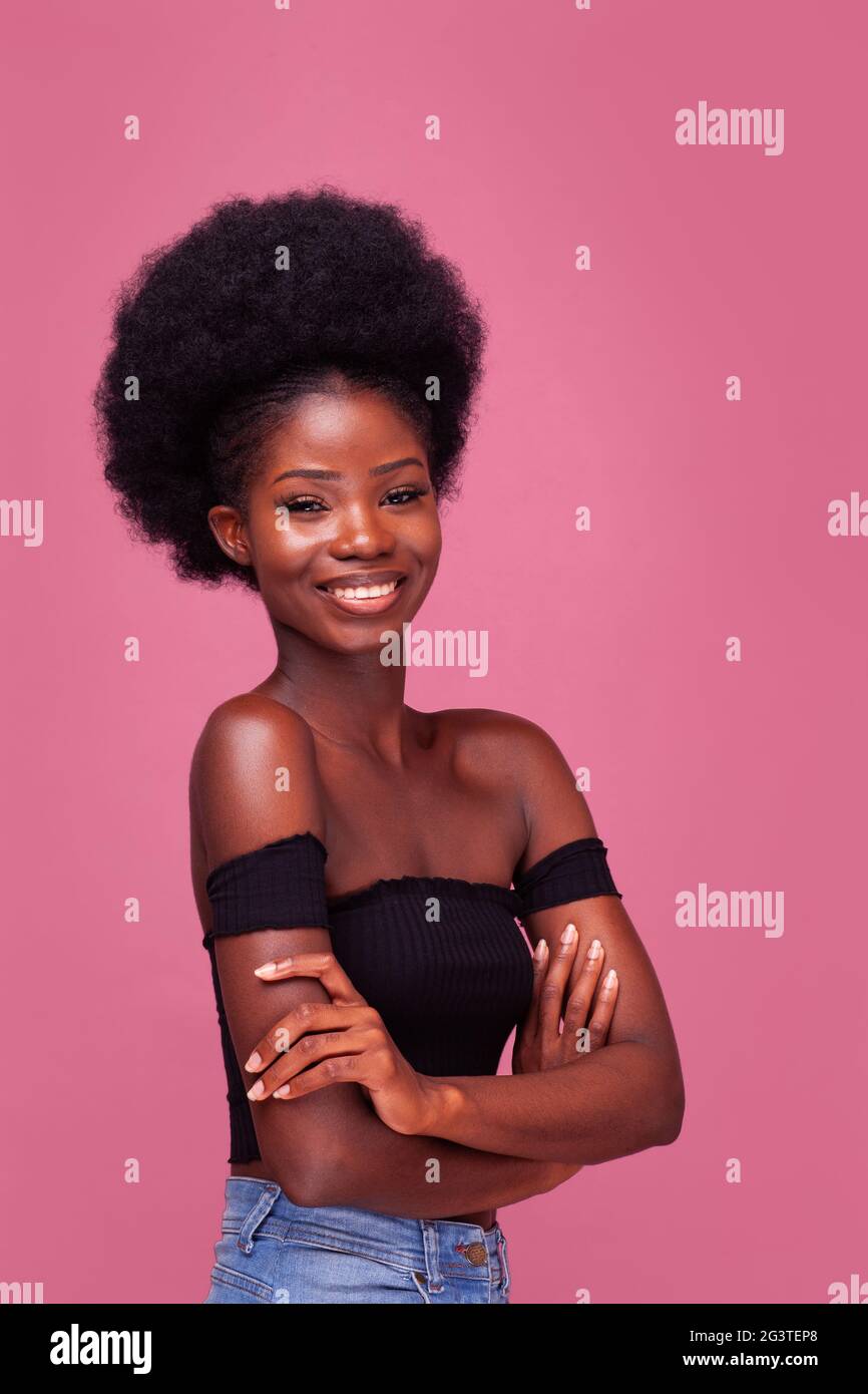 Beautiful African American girl with gorgeous afro hairstyle standing  smiling with arms folded in black top and denim jeans isol Stock Photo -  Alamy