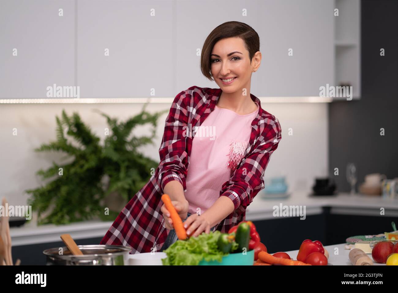 Washing and preparing ingredients on table young woman cooking a lunch standing in the kitchen. Healthy food living. Healthy lif Stock Photo