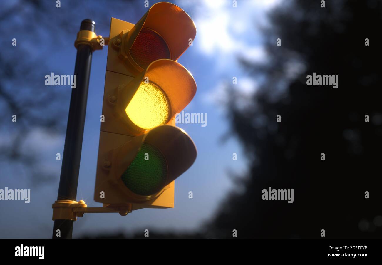 Outdoor vertical traffic light with blue sky and trees around. Traffic control concept image with shallow depth of field. Stock Photo