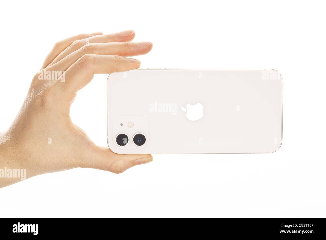Female hand holding the new iPhone 12 White. Stock Photo