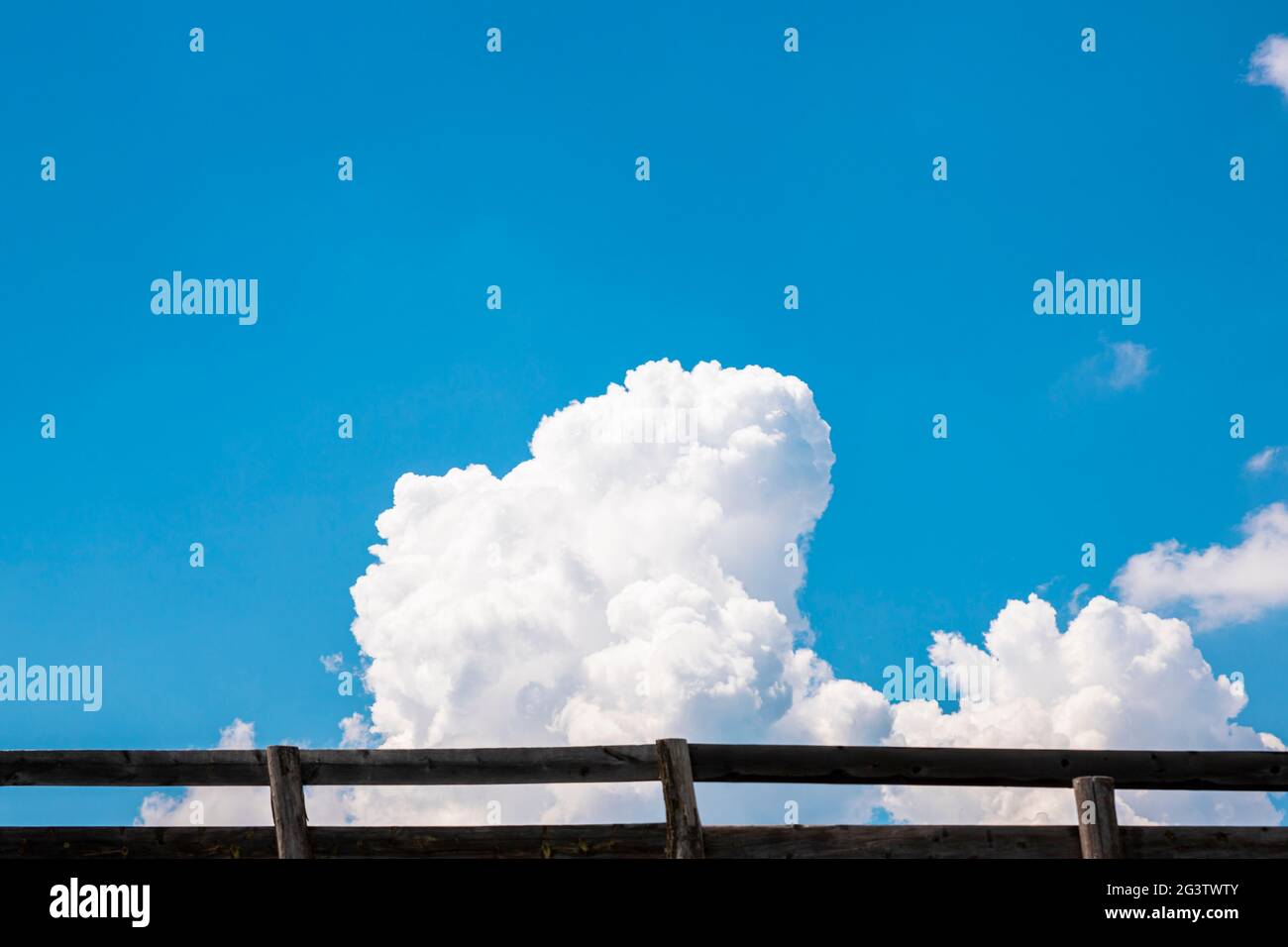 Blue sky and white fluffy clouds behind the wooden fence Stock Photo ...