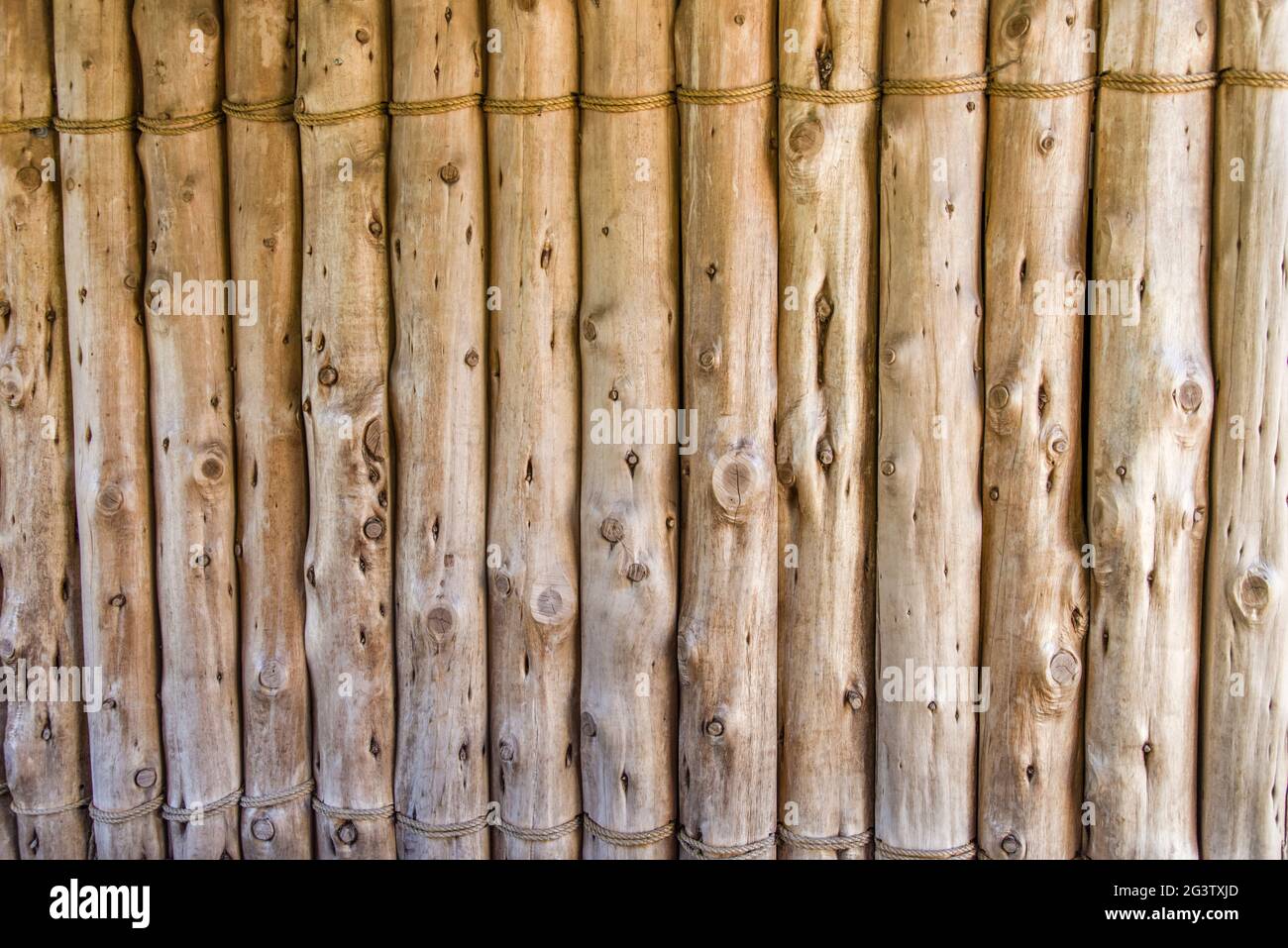 Wooden fence for privacy or security of poles tied together Stock Photo