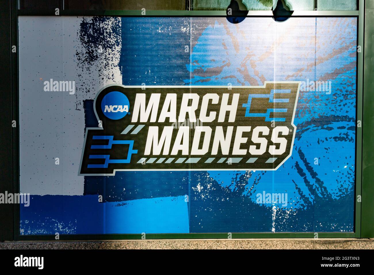 An illuminated March Madness poster in downtown Indianapolis recognizes the NCAA college basketball tournament held in the city. Stock Photo