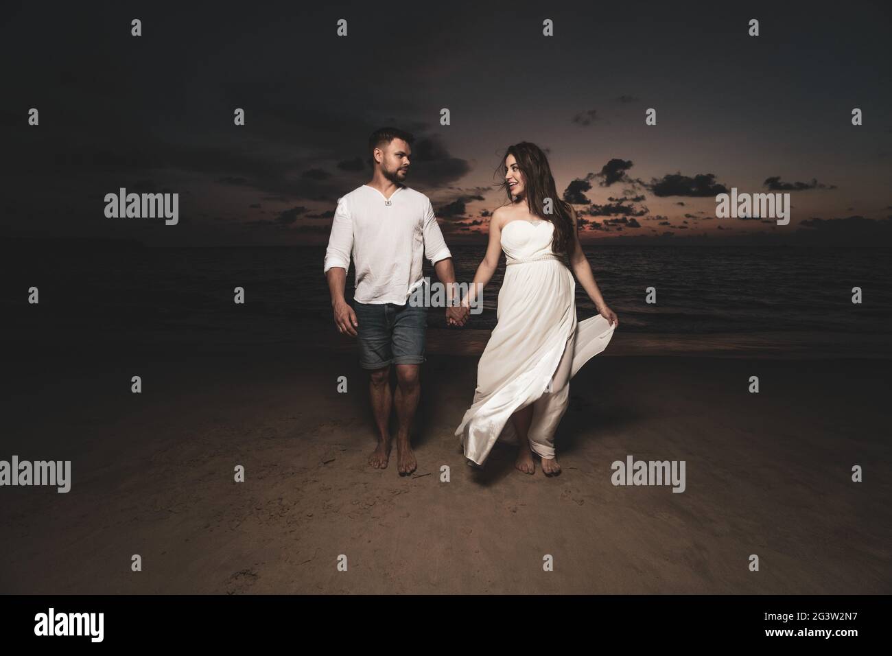 Romantic couple on th beach during sunset Stock Photo - Alamy