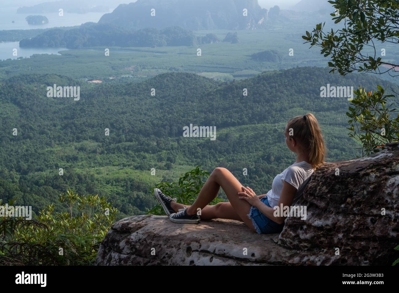Woman taveler sitting on the cliff Stock Photo