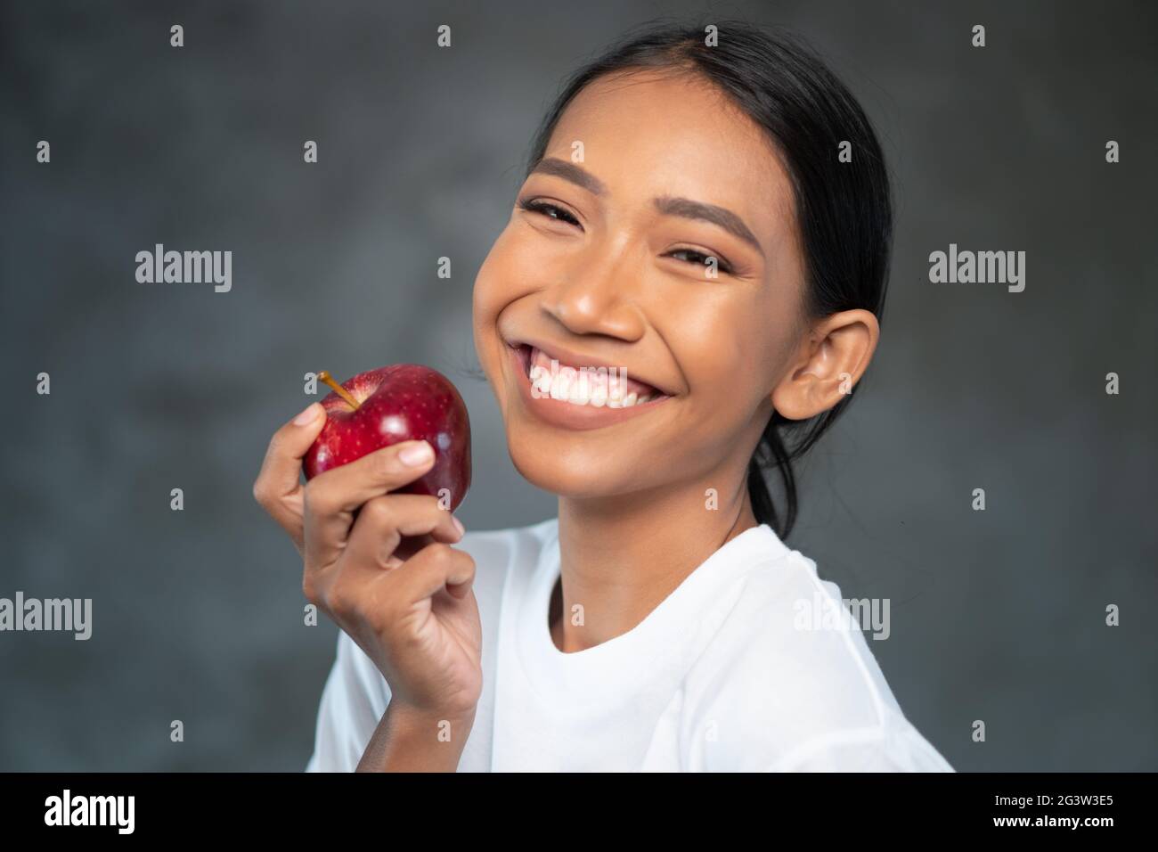 Portrait of beautiful young smiling woman with red apple Stock Photo