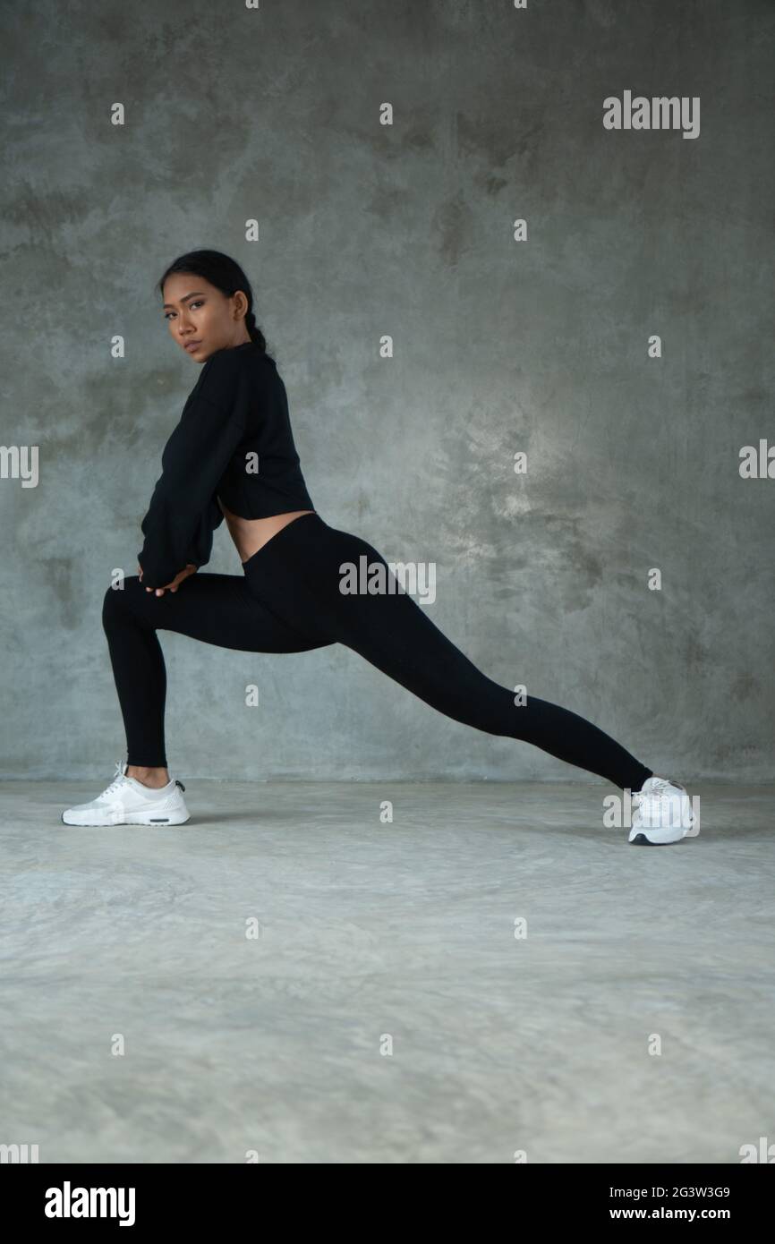 Happy healthy woman stretching at the gym Stock Photo - Alamy