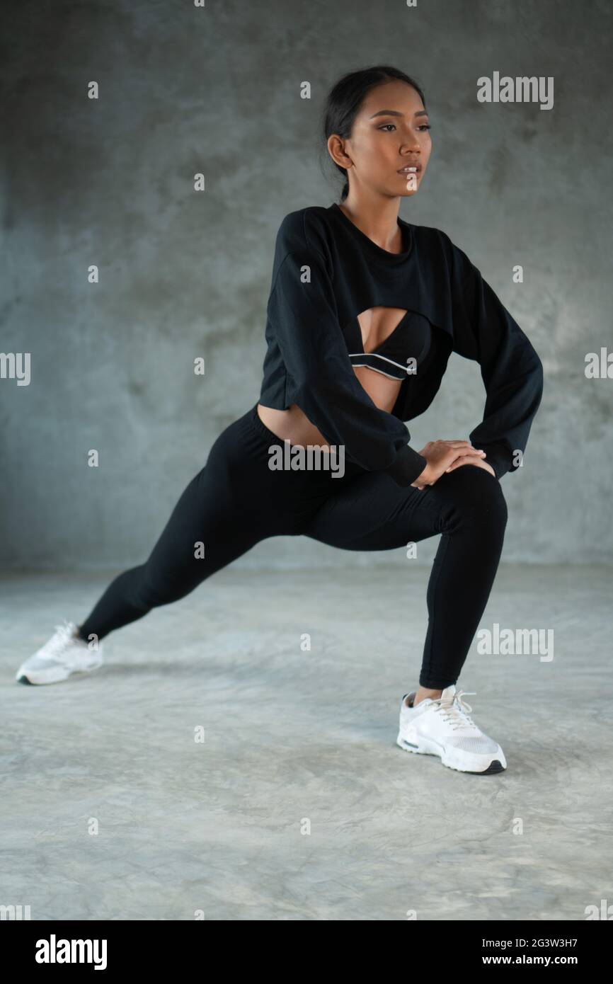 Happy healthy woman stretching at the gym Stock Photo - Alamy