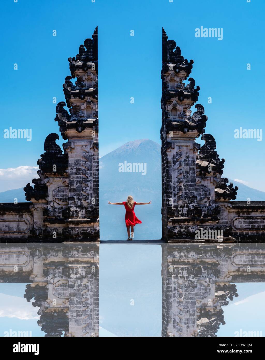 Woman traveler standing at the ancient gates of Pura Luhur Lempuyang temple aka Gates of Heaven in Bali Stock Photo