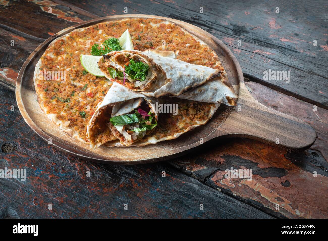 Lahmacun traditional Turkish pizza and wraps with salad on rustic wooden table Stock Photo