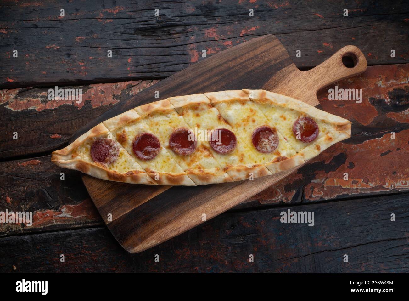 Turkish pide with sausage on rustic wooden table Stock Photo