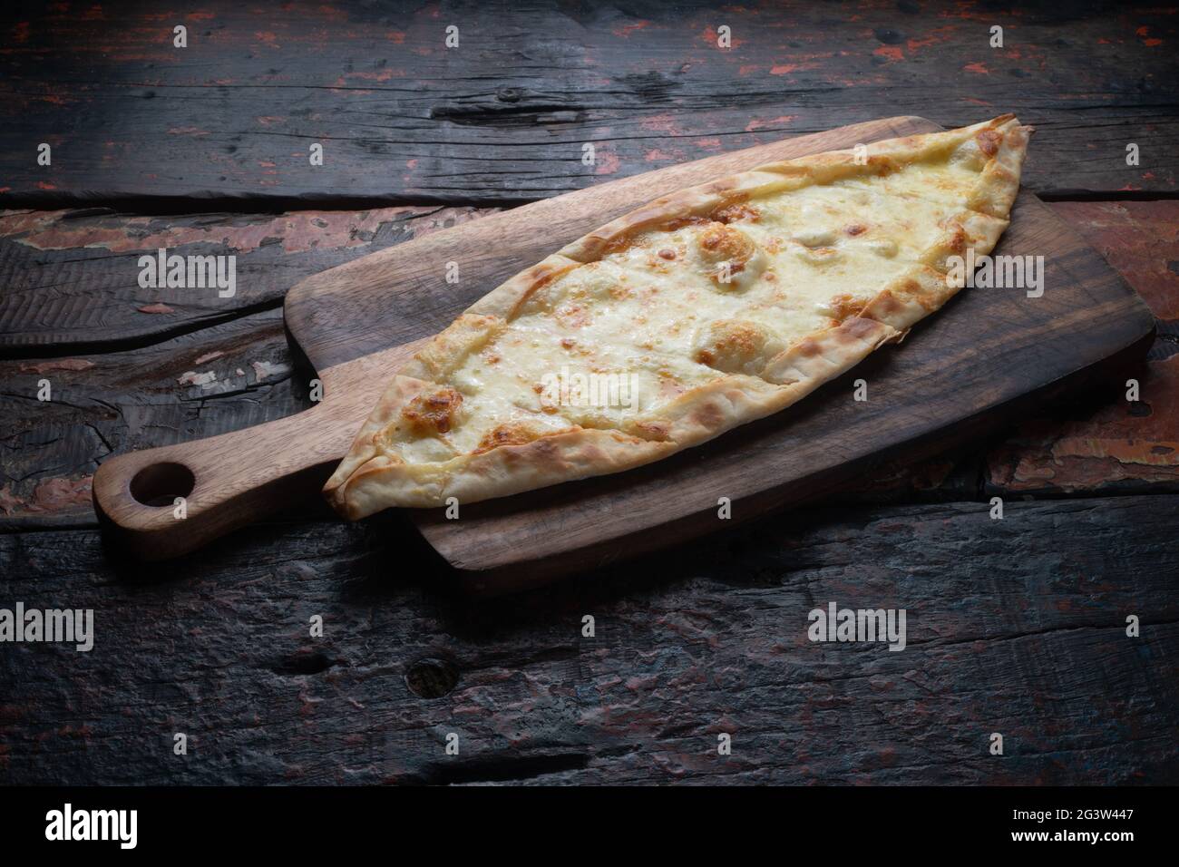 Turkish pide with cheese on rustic wooden table Stock Photo