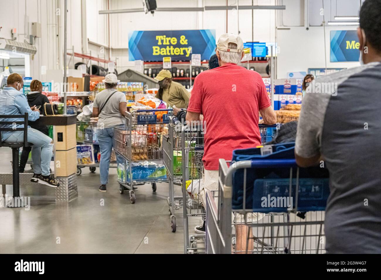Sam's Club membership warehouse store customers wait in line with their purchases to have shopping carts checked in order to to exit the store. (USA) Stock Photo