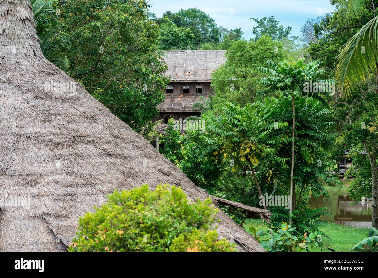 Traditional Melanau tall house and a Bidayuh roundhouse in the Sarawak Cultural Village Stock Photo
