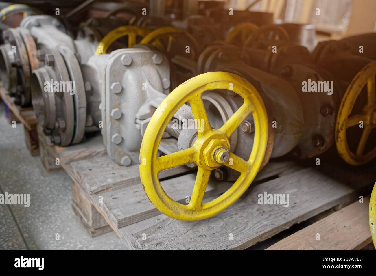 A large shut-off valve lies on a pallet in the warehouse. Storage of gasification equipment. Stock Photo