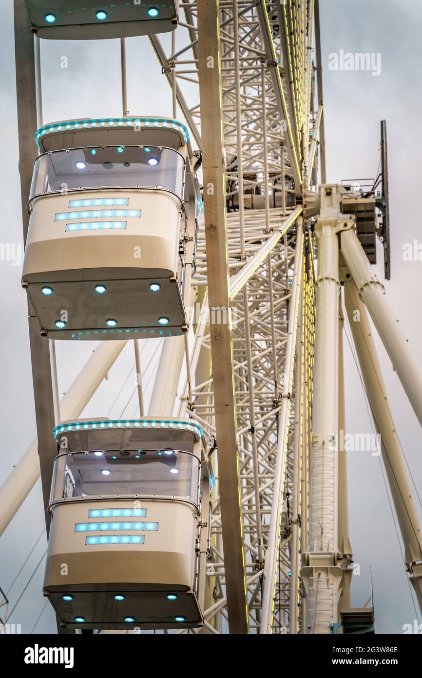 Closeup on gondolas of illuminated cantilevered observation wheel Stock Photo