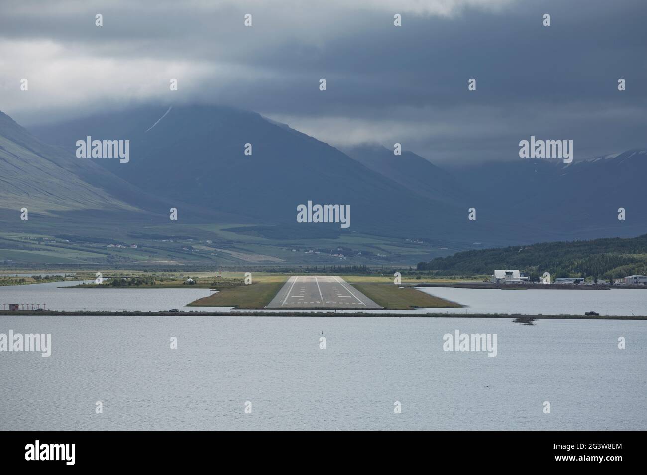 View from the end of runway at Akureyri airport in Iceland. A small plane is taking off Stock Photo