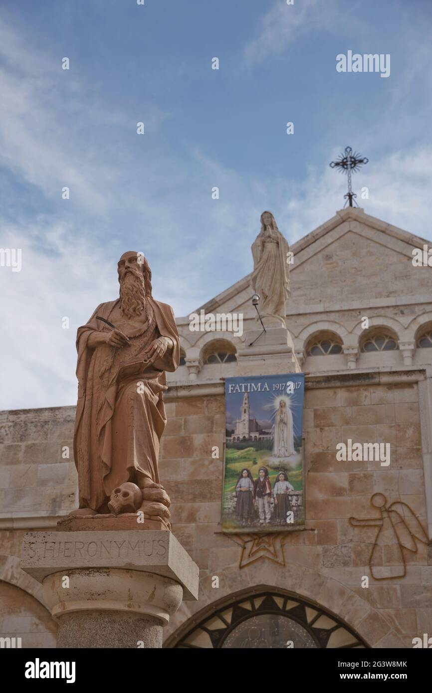 A statue of Saint Hieronymus outside The Church of the Nativity which is a basilica located in the West Bank of Bethlehem Stock Photo