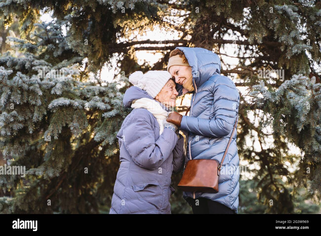 Concept of happy family, old age, emotions, senior care in retirement age. Active senior grandmother and adult daughter hugging Stock Photo