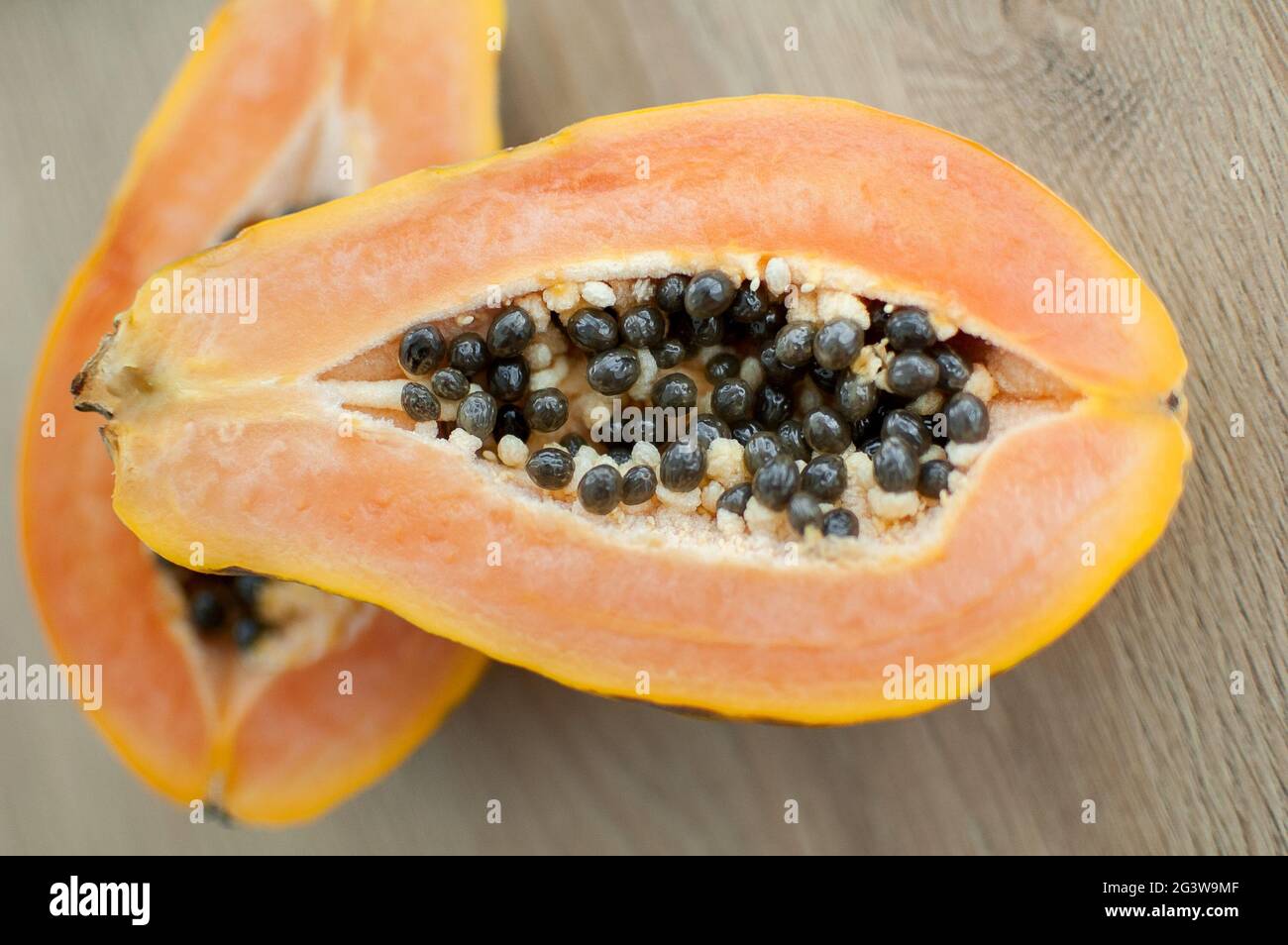 Fresh organic ripe papaya fruit cut in half on a wooden board. Exotic