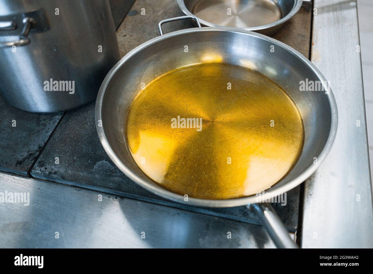 https://c8.alamy.com/comp/2G3WAH2/gray-stylish-aluminum-cookware-on-the-stove-in-the-dining-room-a-round-frying-pan-is-filled-with-vegetable-oil-or-fat-2G3WAH2.jpg