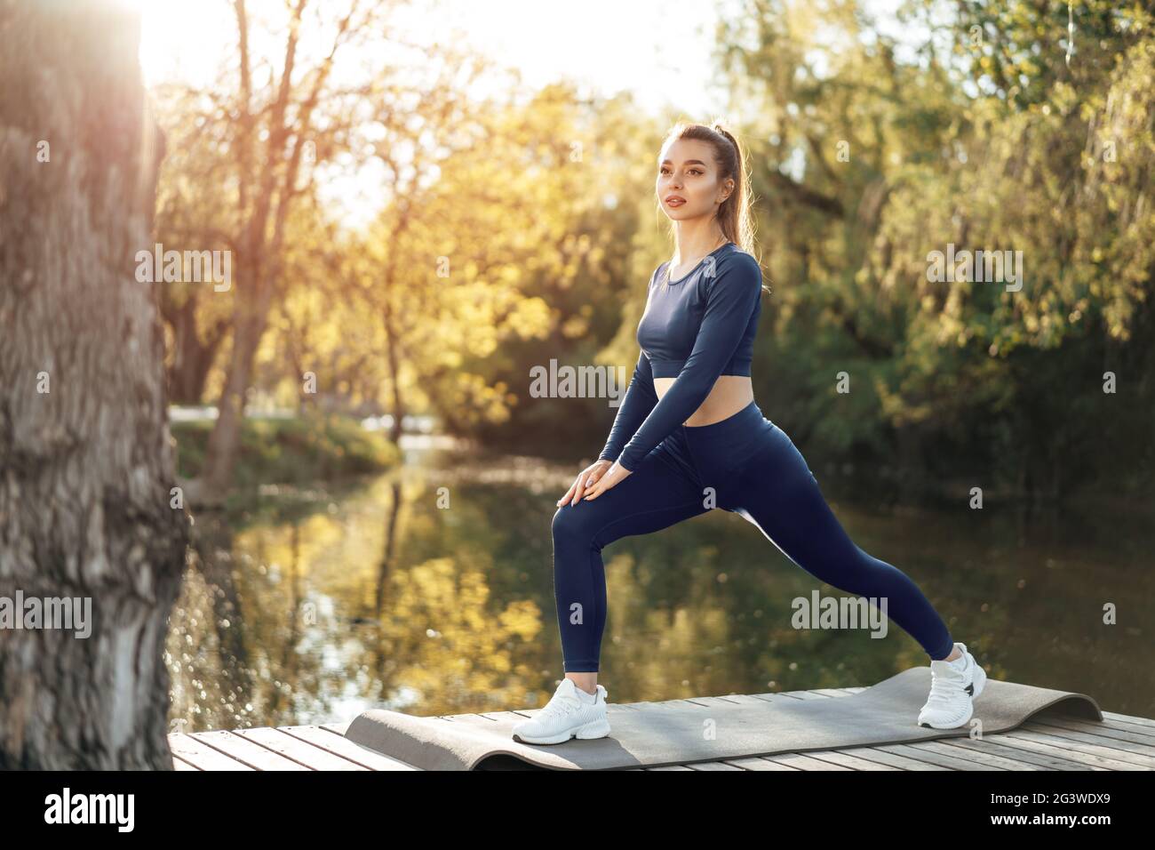 Fit young woman exercising on mat in the park Stock Photo - Alamy