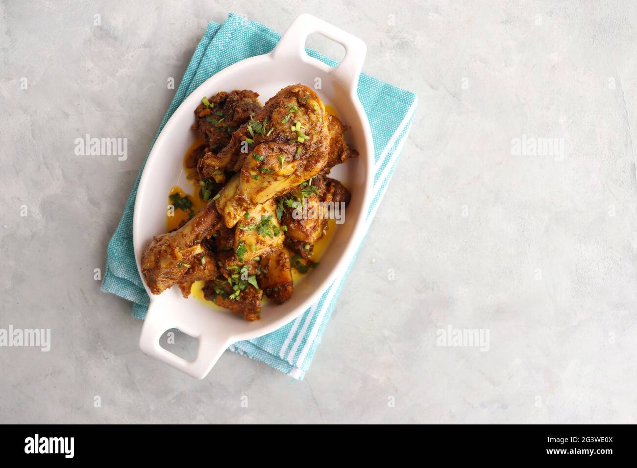 Chicken Tava fry or dry fry. A popular Indian Tawa Murg served in a white plate. Chicken masala garnished with coriander and spices. Copy space. Stock Photo